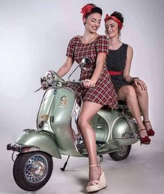 two young women sitting on the back of a scooter posing for a photo