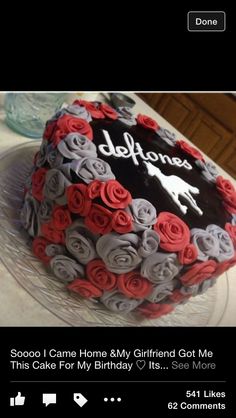 a cake that has been decorated with red and grey roses