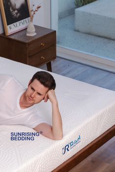 a man laying on top of a mattress in a room