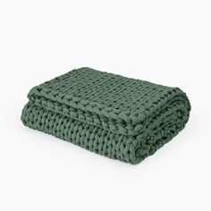 a green knitted blanket on a white background