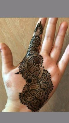 the hand is decorated with henna designs on it, and has an intricate pattern