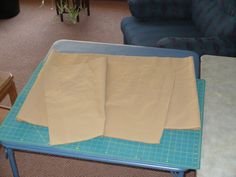 two pieces of brown paper sitting on top of a table next to a blue couch