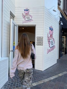 a woman walking out of a building with her back to the camera