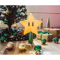 a star decoration sitting on top of a wooden floor next to christmas trees and presents