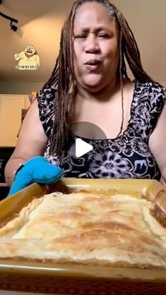 a woman with dreadlocks holding a pancake in front of her face and making a funny face