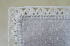 a white crochet doily on top of a table cloth with an intricate design