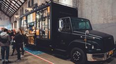 people standing in line to get food from a truck