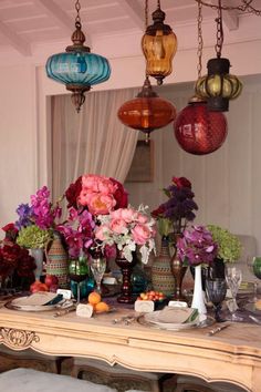 a table topped with lots of vases filled with flowers