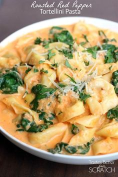 a white bowl filled with pasta and spinach