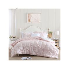 a bed with pink comforter and pillows