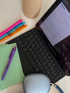 an open laptop computer sitting on top of a desk next to a mouse and pen