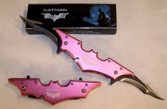 two pink batman knives sitting on top of a table