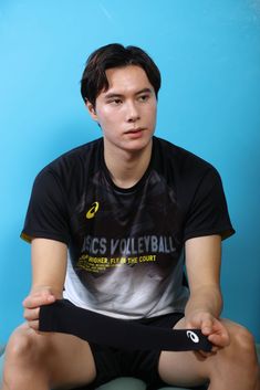 a young man sitting on the floor with his legs crossed