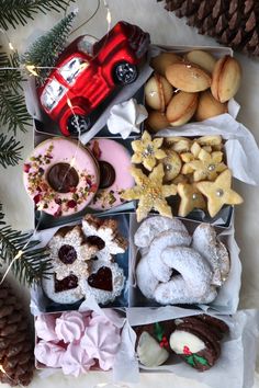 an assortment of cookies and pastries are arranged in a box with pine cones on the side