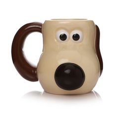 a brown and white dog shaped mug with eyes on it's side, sitting in front of a white background