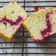 two pieces of cake sitting on top of a cooling rack next to each other with cranberry toppings