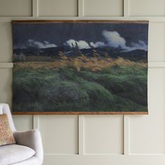 a painting hanging on the wall next to a chair