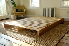 a bed frame sitting on top of a wooden floor next to a radiator