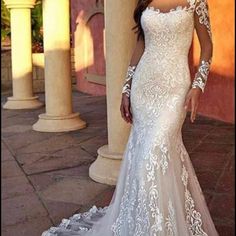 a woman in a white wedding dress posing for the camera with her hands on her hips