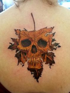 a woman's back with a skull and leaves on it