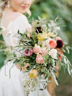 a woman holding a bouquet of flowers in her hands