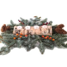 a candle holder made out of wood with pine cones and berries on the top, surrounded by evergreen branches