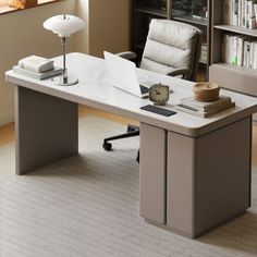 an office desk with a chair, lamp and bookshelf in front of it