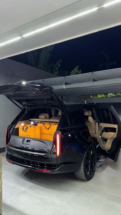 an suv is parked in the garage with its doors open and it's trunk opened