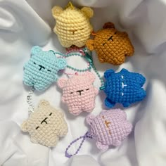 four crocheted key chains with small teddy bears on them, all in different colors