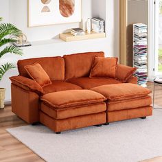 an orange couch sitting on top of a white rug