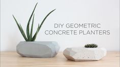 two cement planters sitting next to each other on top of a wooden table with the words diy geometric concrete planters