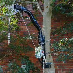 a crane attached to a tree in front of a brick wall