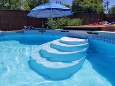 an empty swimming pool with steps in the water