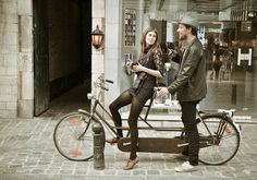 a man and woman standing next to a bicycle