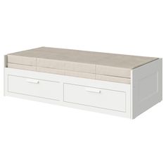 a white bed with two drawers underneath it