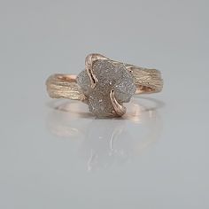 a gold and white diamond ring sitting on top of a table