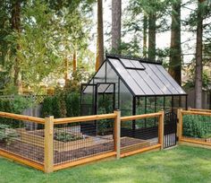 a small greenhouse in the middle of a yard