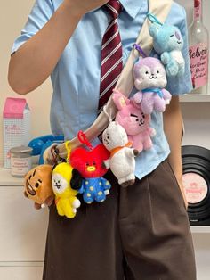 a man holding a bunch of stuffed animals in his pocket while talking on the phone