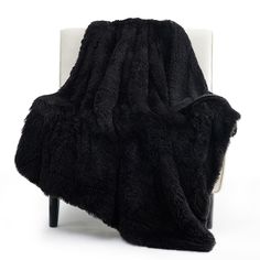 a black blanket sitting on top of a white chair