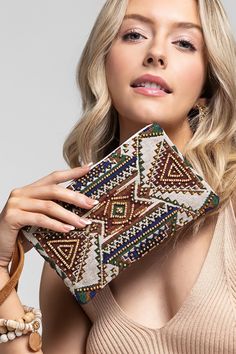 This Handmade Aztec Seed Bead Clutch is perfect for adding a pop of color to any outfit! Made with fine cotton and carefully handcrafted with a fun geometric pattern, this clutch also features intricate seed bead detailing and a leather strap making it a unique accessory. Elevate your style with this one-of-a-kind piece! 5.5 x 8.5 handcrafted in India Southern Roots Boutique112 W Main St Paragould, AR Bohemian Beaded Clutch, Bohemian Beaded Festival Clutch, Bohemian Beaded Pouch Clutch, Bohemian Beaded Clutch For Everyday Use, Chic Multicolor Handmade Clutch, Chic Handmade Multicolor Clutch, Handmade Multicolor Chic Clutch, Multicolor Woven Bohemian Clutch, Bohemian Multicolor Embroidery Clutch