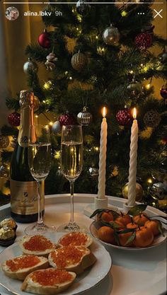 a table topped with plates of food next to a christmas tree