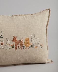 an embroidered pillow with animals on it