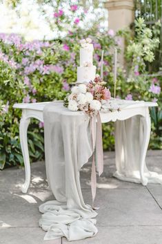 a wedding cake on a table with flowers