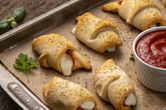 several pastries on a baking sheet with sauce