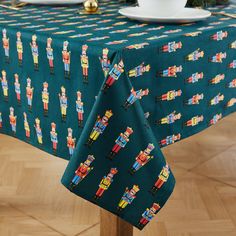 a green table cloth with nutcrackers on it and place setting for two