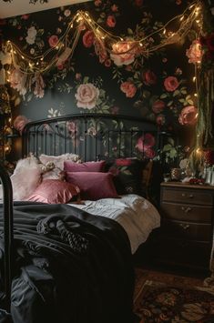 a bedroom with floral wallpaper and lights strung from the ceiling over the headboard