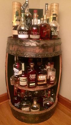 a wooden barrel filled with lots of liquor bottles