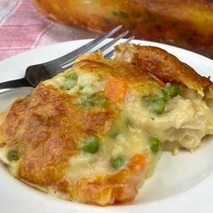 a white plate topped with an omelet covered in cheese and veggies