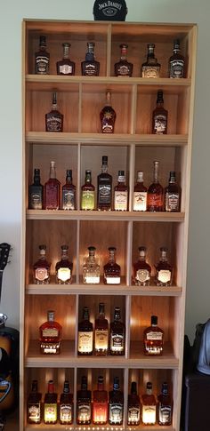 a shelf filled with lots of different types of liquor bottles on top of wooden shelves