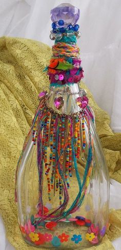 a glass bottle filled with lots of colorful beads